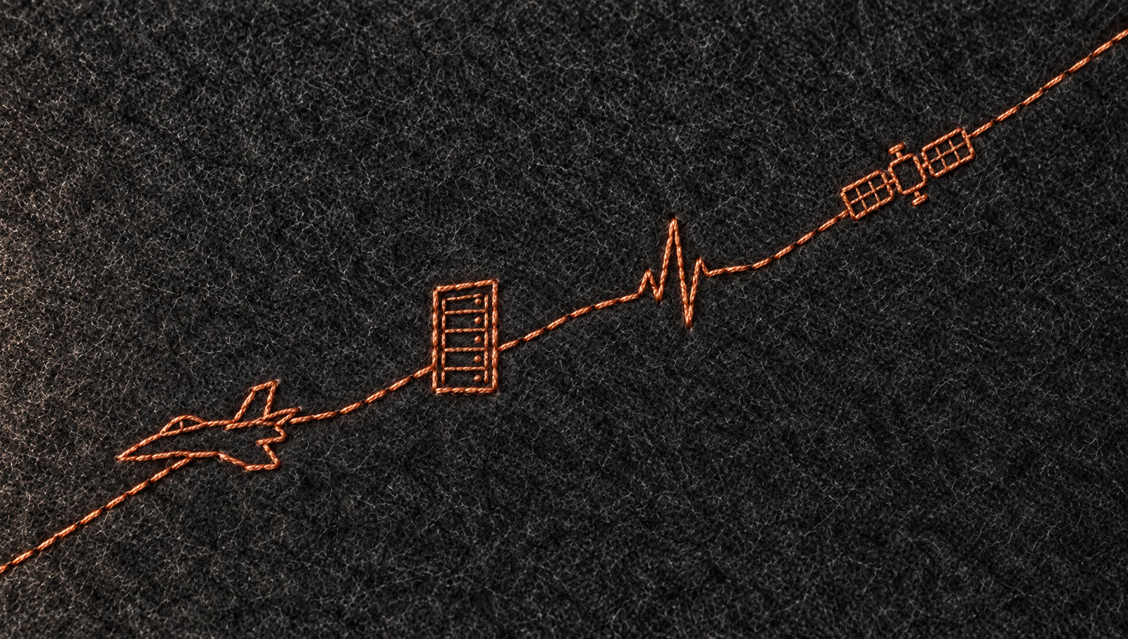 Copper thread embroidery of a jet, server rack, heartbeat and satellite on felt